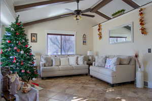 Living room with lofted ceiling with beams and ceiling fan