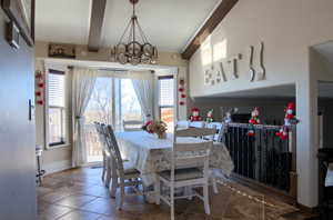 Tiled dining room featuring beam ceiling and an inviting chandelier