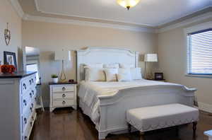 Bedroom with crown molding and dark hardwood / wood-style floors