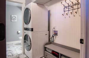 Clothes washing area featuring stacked washer and clothes dryer