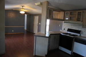 Kitchen featuring ceiling fan, dark hardwood / wood-style flooring, kitchen peninsula, a textured ceiling, and white appliances