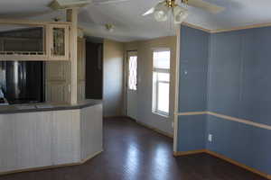 Kitchen with ceiling fan, dark hardwood / wood-style flooring, crown molding, a textured ceiling, and black refrigerator