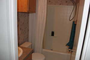 Full bathroom featuring shower / bath combo, vanity, and toilet