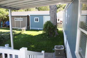 View of yard with a storage unit and central air condition unit