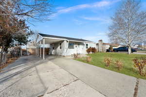 Ranch-style house with a carport and a front yard