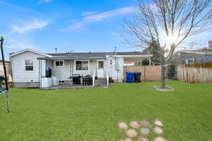 Rear view of house with a lawn, a patio area, and a trampoline