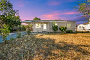 View of front of home featuring a carport, entry steps, and driveway