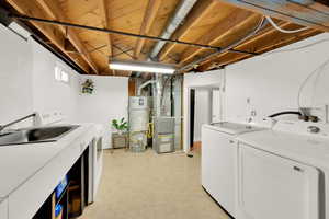 Washroom with washing machine and clothes dryer, strapped water heater, and heating unit