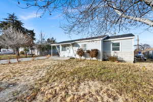 Ranch-style home with a front yard and covered porch