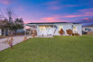 View of front of home featuring a lawn and a carport