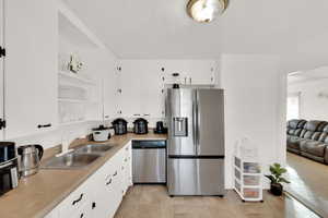 Kitchen featuring sink, white cabinetry, and stainless steel appliances