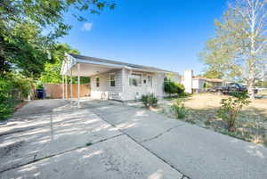 View of front facade with concrete driveway and an attached carport