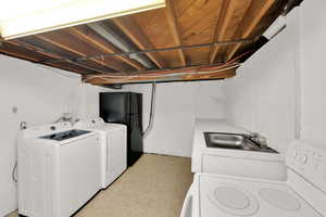 Washroom featuring washing machine and dryer and light tile patterned flooring