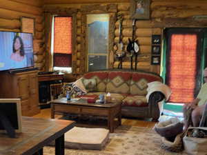 Living room with log walls and wood-style floor