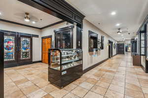 Hallway featuring ornamental molding and french doors