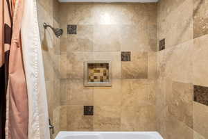 Bathroom with shower / bath combination with curtain