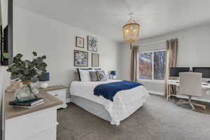 Carpeted bedroom with a notable chandelier