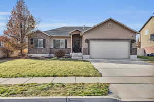 Ranch-style home featuring a front yard and a garage