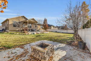 Rear view of house with a patio, an outdoor fire pit, and a lawn