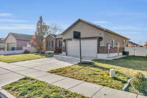 Ranch-style home featuring cooling unit, a garage, and a front lawn