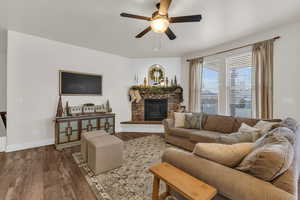 Living room featuring hardwood / wood-style floors, ceiling fan, and a fireplace