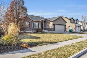 Single story home with a front yard and a garage