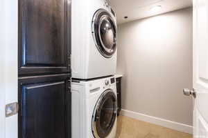 Washroom featuring stacked washer / drying machine