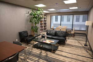 Living room with a drop ceiling and built in features