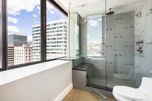 Bathroom featuring plenty of natural light, toilet, and a shower with shower door