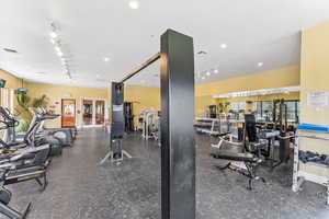 Workout area featuring french doors and track lighting