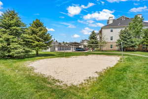 View of property's community with a lawn and volleyball court