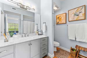 Bathroom with wood-type flooring, vanity, and toilet