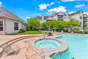 View of pool with a patio and a hot tub