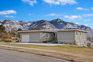 View of front facade featuring a mountain view, solar panels, and a garage