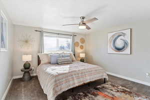 Carpeted bedroom featuring ceiling fan