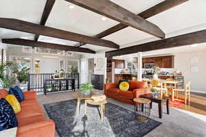 Living room with lofted ceiling with beams and wood-type flooring