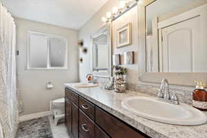 Bathroom featuring tile patterned flooring, vanity, and toilet