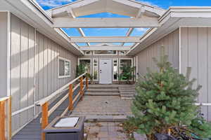 Doorway to property featuring a pergola