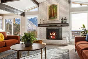 Sunroom / solarium with a fireplace and lofted ceiling with beams