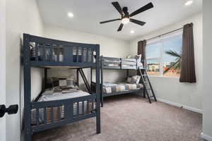 Carpeted bedroom featuring ceiling fan