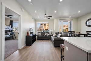 Living room featuring ceiling fan, a healthy amount of sunlight, and light wood-type flooring