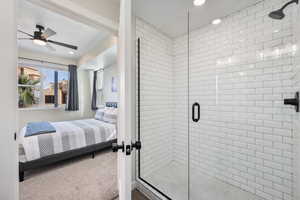 Bathroom featuring ceiling fan and a shower with shower door