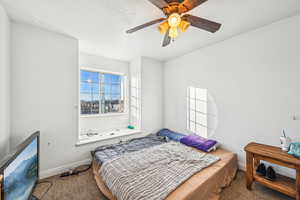 Bedroom featuring ceiling fan, carpet floors, and a textured ceiling