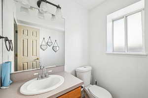 Bathroom with vanity, toilet, and a wealth of natural light