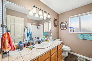 Bathroom with a shower with shower curtain, vanity, and toilet