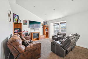 Carpeted living room with lofted ceiling