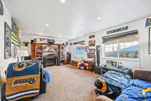 Bedroom with a fireplace and carpet floors