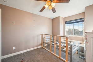 Carpeted bedroom with ceiling fan and a textured ceiling