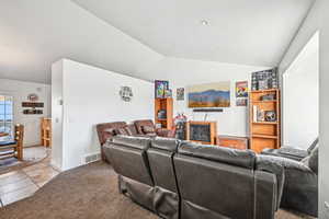 Living room with light carpet and vaulted ceiling