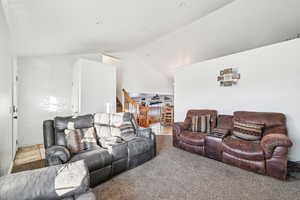 Living room featuring carpet flooring and high vaulted ceiling